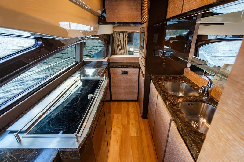 Vitamin Sea Yacht Photos Pics Luxurious kitchen interior of 2011 Azimut 70 Fly yacht with modern appliances and wood finishes.