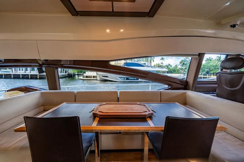 Vitamin Sea Yacht Photos Pics Interior view of 2011 Azimut 70 Fly yacht, featuring elegant dining area with waterfront backdrop.