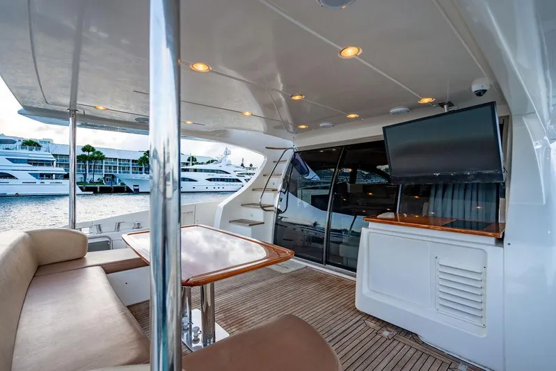 Vitamin Sea Yacht Photos Pics Luxurious 2011 Azimut 70 Fly yacht deck with seating, table, and TV, docked at marina.