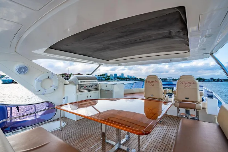 Vitamin Sea Yacht Photos Pics Luxurious 2011 Azimut 70 Fly yacht deck with dining area and scenic waterfront view.