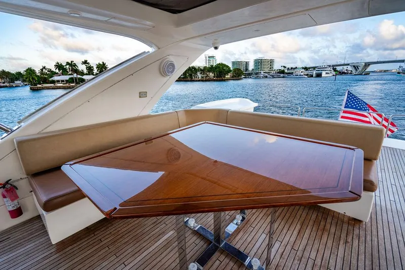 Vitamin Sea Yacht Photos Pics Luxurious 2011 Azimut 70 Fly yacht deck with elegant wooden table and scenic waterfront view.