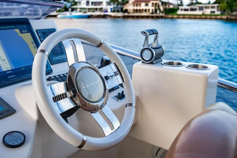 Vitamin Sea Yacht Photos Pics Steering wheel of 2011 Azimut 70 Fly yacht with water view in background.