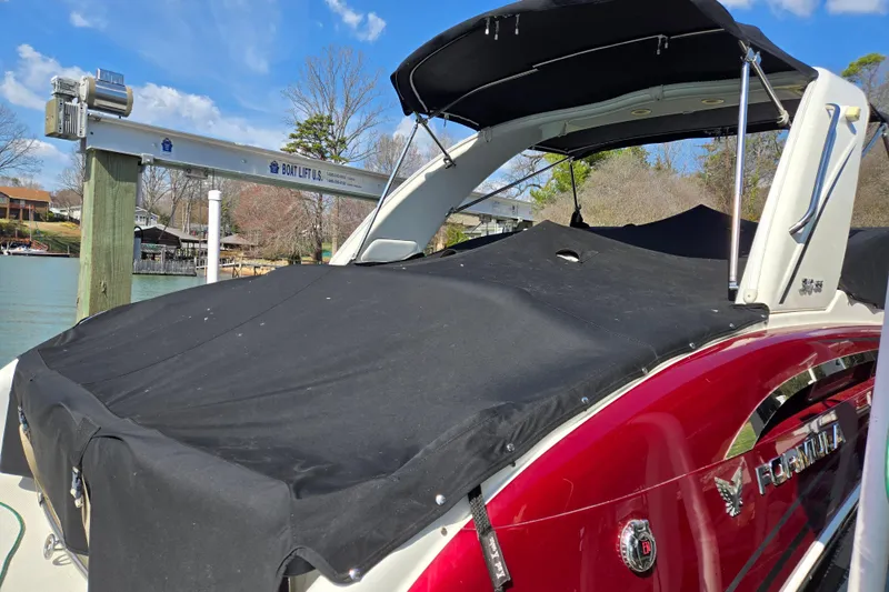 Yacht Photos Pics 2017 Formula 310 Sun Sport boat with black cover docked by a lake.