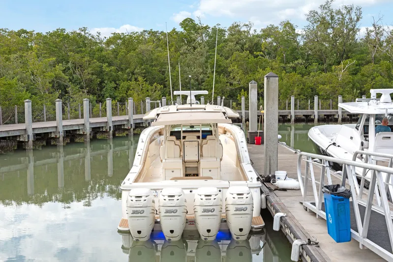  Yacht Photos Pics 2018 Scout 420 LXF boat docked with four engines, surrounded by lush greenery.