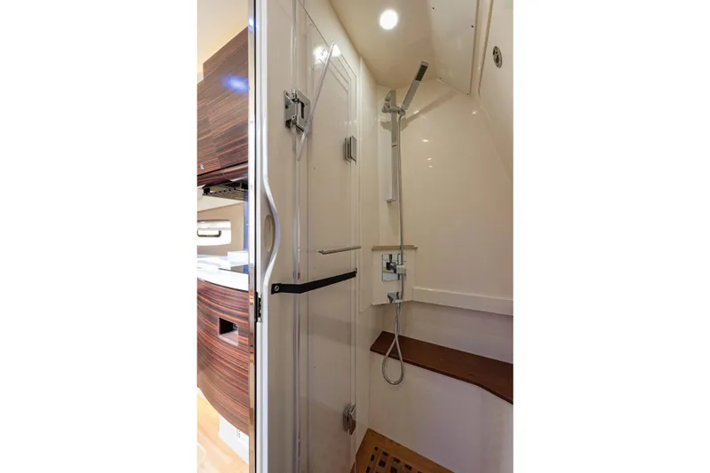  Yacht Photos Pics Luxurious shower area in 2018 Scout 420 LXF boat, featuring modern fixtures and wooden accents.