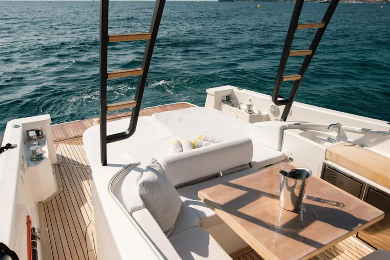  Yacht Photos Pics Luxurious 2019 Bluegame BG42 yacht deck with seating, table, and ocean view.