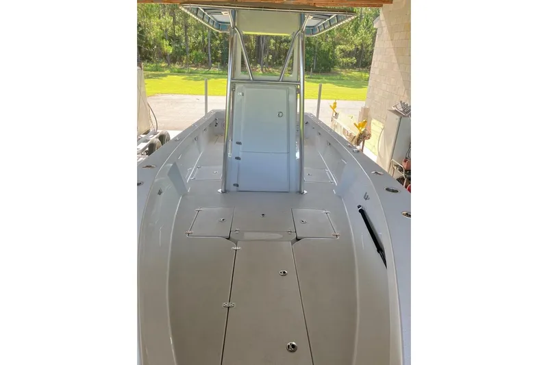  Yacht Photos Pics 2024 Latitude Tournament Boats 25, sleek deck view, under shelter, surrounded by greenery.