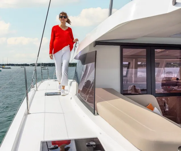 Fp41 In San Diego. Ex-factory Sept. 2025 Yacht Photos Pics Woman walking on 2025 Fountaine Pajot NEW 41 yacht deck, wearing red and white outfit.