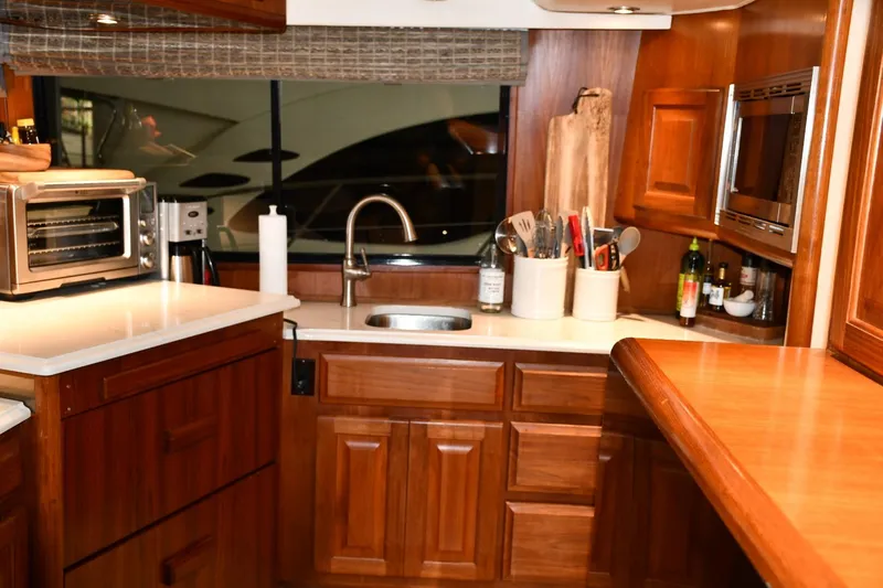 Lay A Wake Yacht Photos Pics Luxurious kitchen interior of 1990 Viking 53 Convertible yacht with wooden cabinetry.