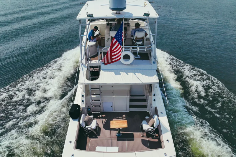 Lay A Wake Yacht Photos Pics 1990 Viking 53 Convertible yacht cruising with American flag on open water.