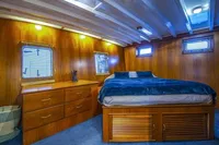 Cozy wooden cabin interior with bed and dresser on 1987 Aberdeen Marina Complex Chinese wood junk.