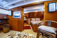 Interior of 1987 Aberdeen Marina Complex Chinese wood junk, featuring cozy wooden decor and seating.