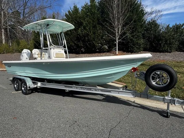 2025 Bulls Bay 2400 boat on trailer, parked outdoors, with trees in the background.