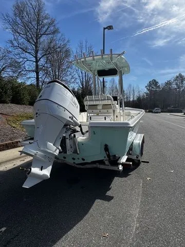 2025 Bulls Bay 2400 boat with outboard motor on a trailer, parked on a sunny street.