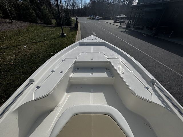 2025 Bulls Bay 2400 boat bow view, parked on a street near greenery.