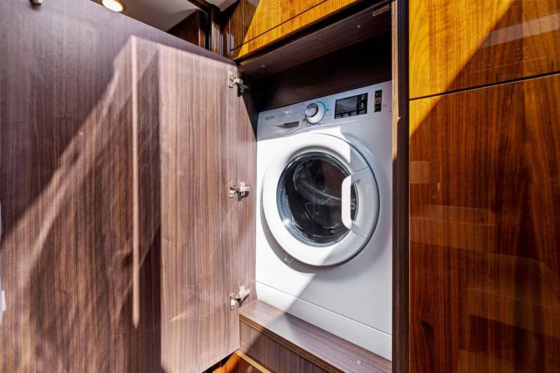 Gt50/251 Yacht Photos Pics Washing machine inside Fairline Targa 50 GT yacht, 2025 model, with wooden cabinetry.