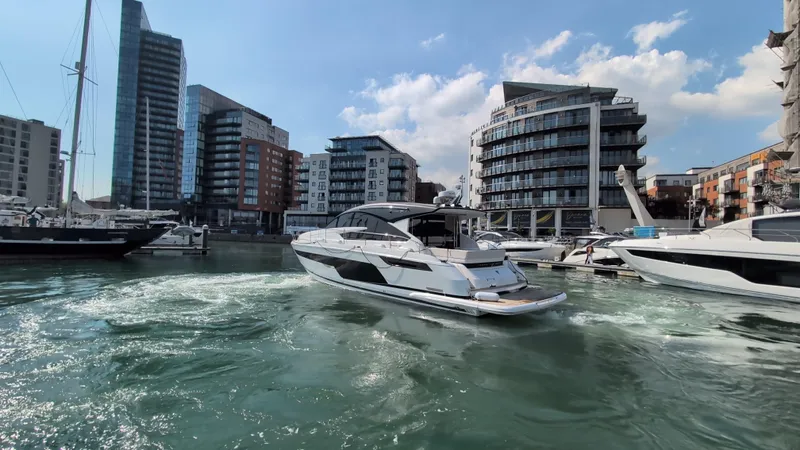 Gt50/251 Yacht Photos Pics 2025 Fairline Targa 50 GT yacht cruising in a modern marina with cityscape backdrop.