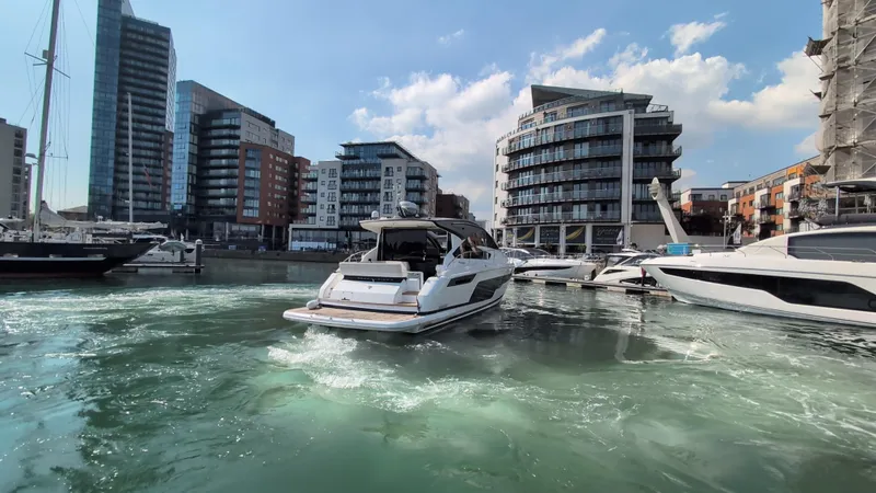 Gt50/251 Yacht Photos Pics 2025 Fairline Targa 50 GT yacht cruising in a modern marina with cityscape backdrop.