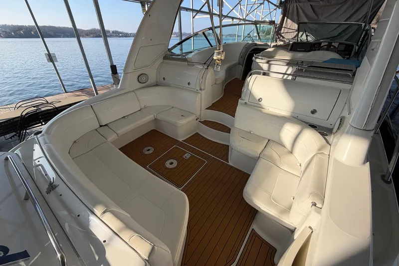  Yacht Photos Pics 2005 Formula 48 Yacht interior with white seating and wooden flooring, docked by a serene lake.