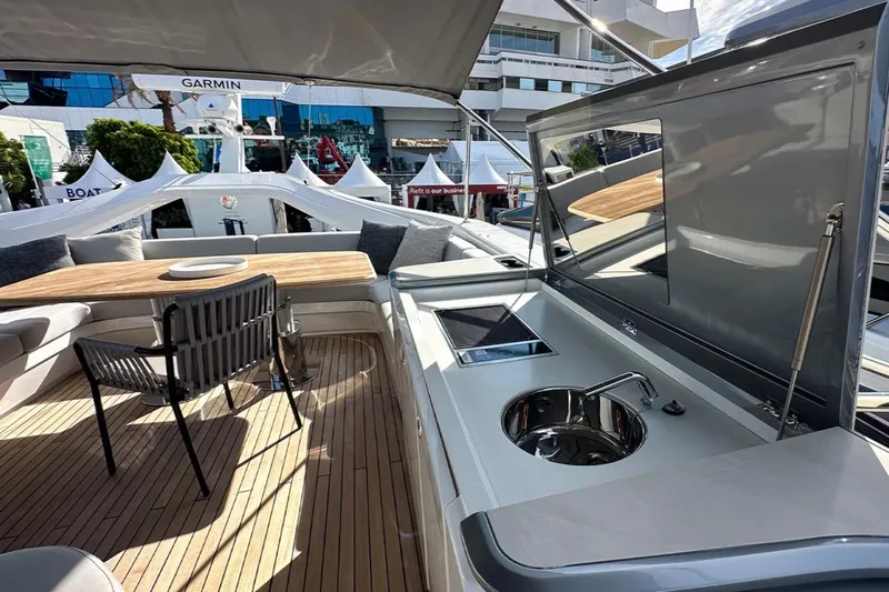  Yacht Photos Pics Luxurious 2025 Princess S80 yacht deck with seating, table, and kitchenette.