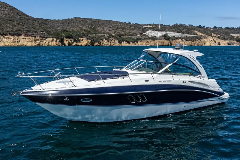 Cruel Summer Yacht Photos Pics 2012 Cruisers 380 Express yacht on blue ocean near rocky coastline.