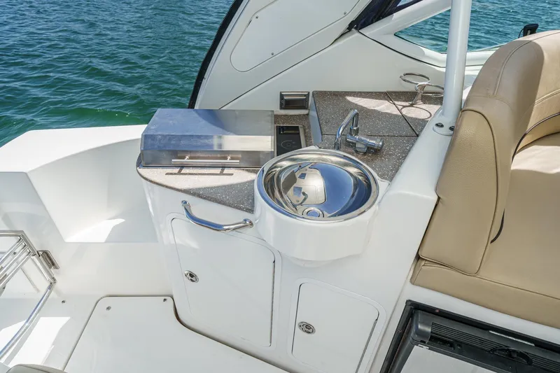 Cruel Summer Yacht Photos Pics 2012 Cruisers 380 Express yacht kitchenette with sink and grill, overlooking water.