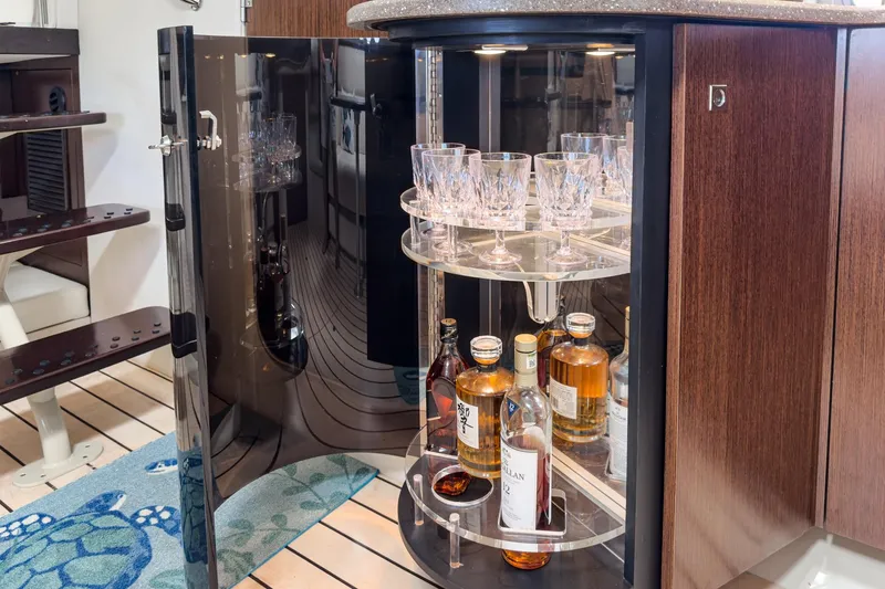 Cruel Summer Yacht Photos Pics Luxurious bar cabinet on 2012 Cruisers 380 Express yacht, featuring crystal glasses and premium liquor.