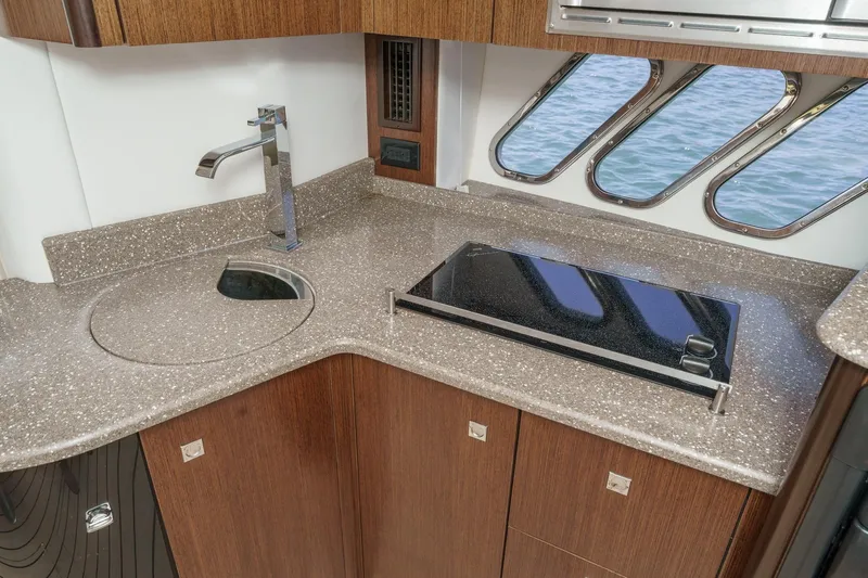 Cruel Summer Yacht Photos Pics 2012 Cruisers 380 Express yacht kitchen with modern sink, stovetop, and ocean view windows.