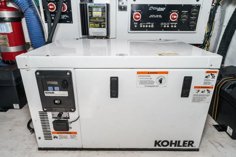 Cruel Summer Yacht Photos Pics Kohler generator in 2012 Cruisers 380 Express engine room with control panel and safety warnings.
