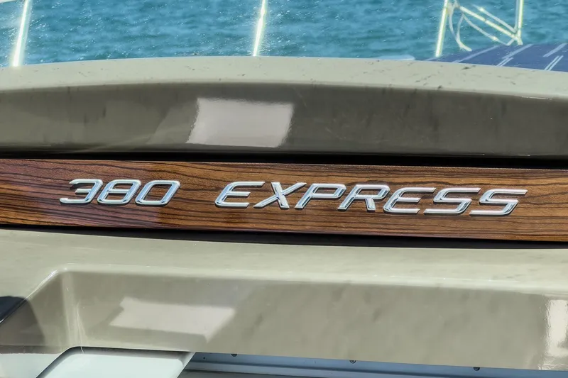 Cruel Summer Yacht Photos Pics 2012 Cruisers 380 Express boat nameplate with wood finish, against a blue water backdrop.