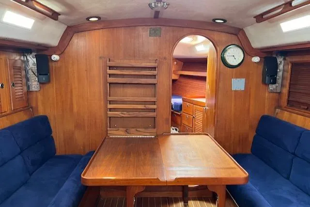 Lightwave Yacht Photos Pics Interior of 1994 J Boats J 44 sailboat with wooden table and blue seating.