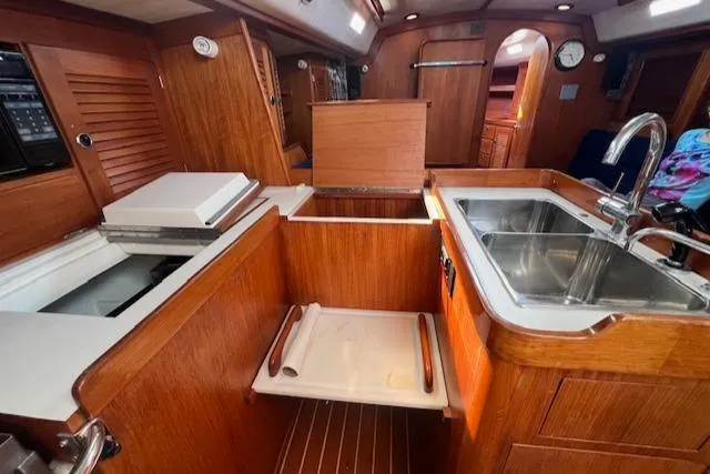 Lightwave Yacht Photos Pics Interior of 1994 J Boats J 44 sailboat featuring a wooden galley with sink and storage.