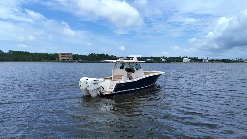Engine Warranty X Trailer Yacht Photos Pics 2022 Scout 330 LXF boat on calm water under a partly cloudy sky.