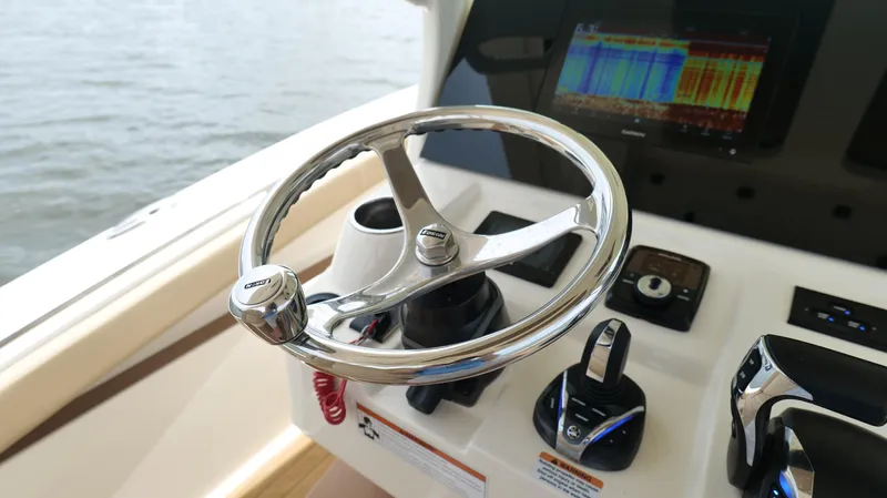 Engine Warranty X Trailer Yacht Photos Pics Steering wheel and controls of 2022 Scout 330 LXF boat, featuring advanced navigation display.