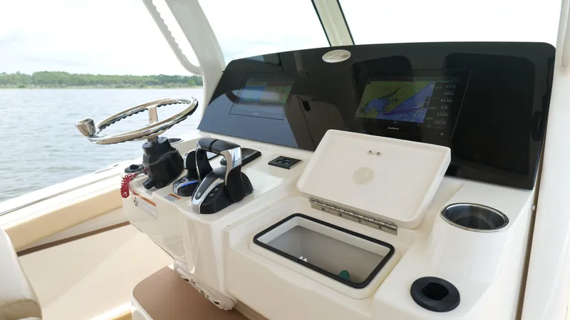 Engine Warranty X Trailer Yacht Photos Pics 2022 Scout 330 LXF boat dashboard with navigation screens and steering wheel.