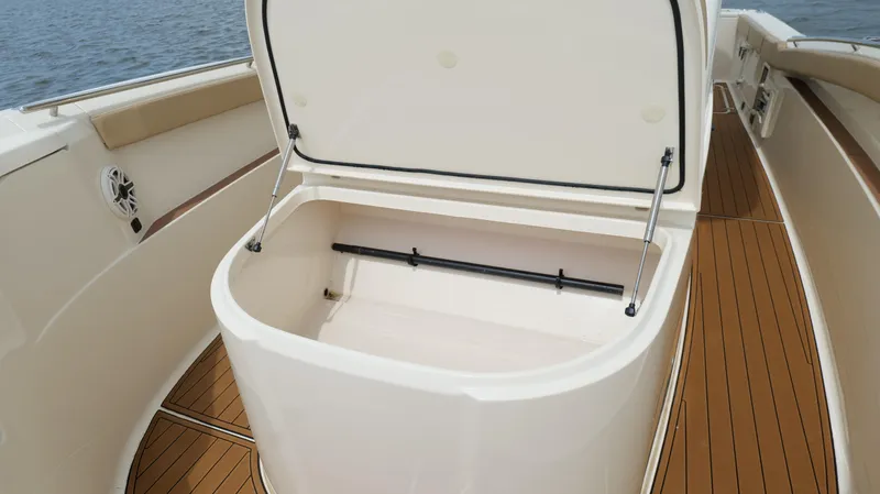 Engine Warranty X Trailer Yacht Photos Pics Open storage compartment on 2022 Scout 330 LXF boat with teak flooring.