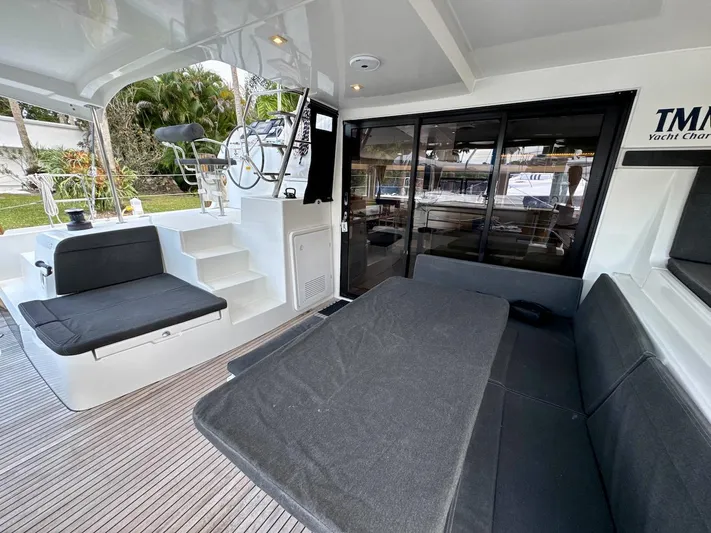 Orion Yacht Photos Pics 2019 Lagoon 42 yacht cockpit with seating, helm, and sliding glass doors.