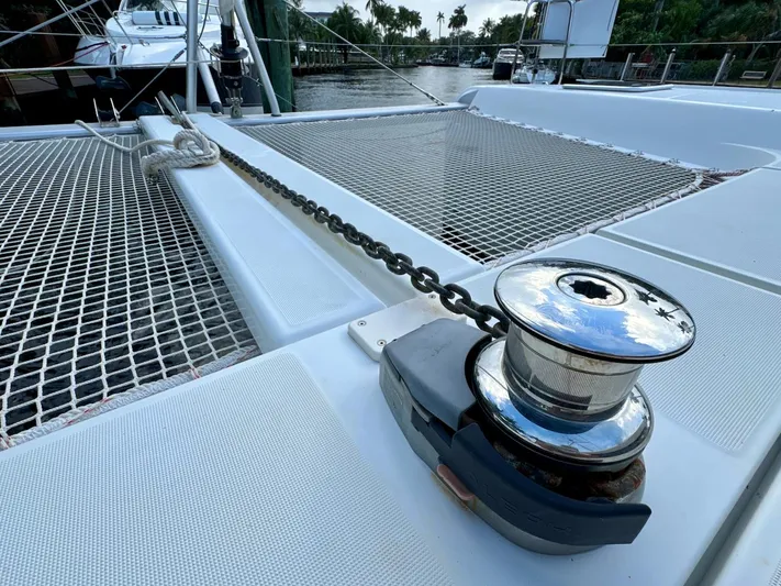 Orion Yacht Photos Pics 2019 Lagoon 42 catamaran deck with winch and chain, docked by the water.