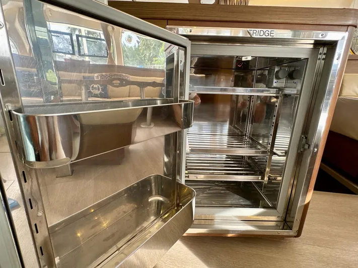Orion Yacht Photos Pics Open stainless steel fridge inside 2019 Lagoon 42 yacht, showcasing interior shelving.