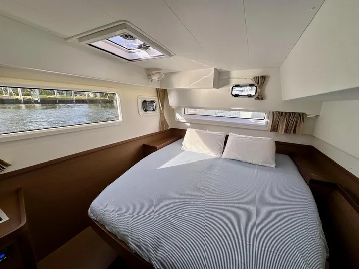 Orion Yacht Photos Pics Interior cabin of 2019 Lagoon 42 catamaran with cozy bed and scenic window views.