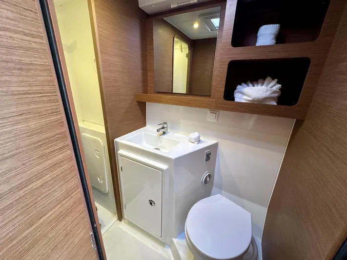 Orion Yacht Photos Pics Bathroom interior of 2019 Lagoon 42 catamaran with sink, toilet, and storage shelves.