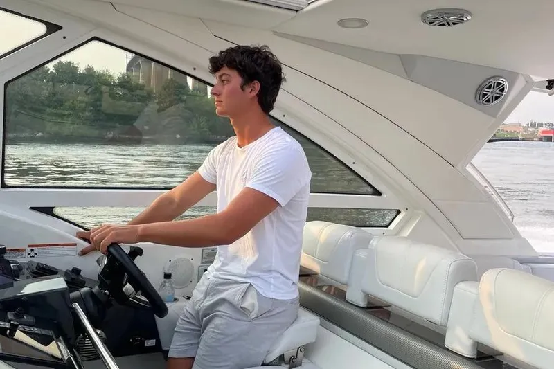  Yacht Photos Pics Young man steering a 2020 Formula 400 Super Sport Crossover on a calm river.