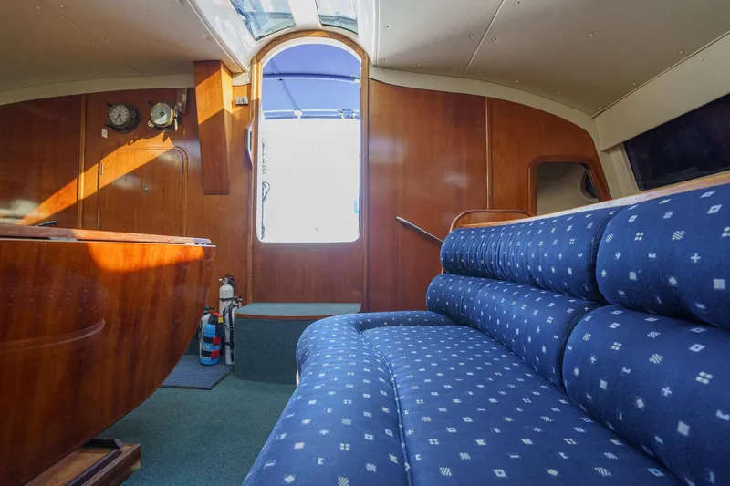 Solitude Yacht Photos Pics Interior of 1995 Prout 45 yacht with blue patterned seating and wooden paneling.