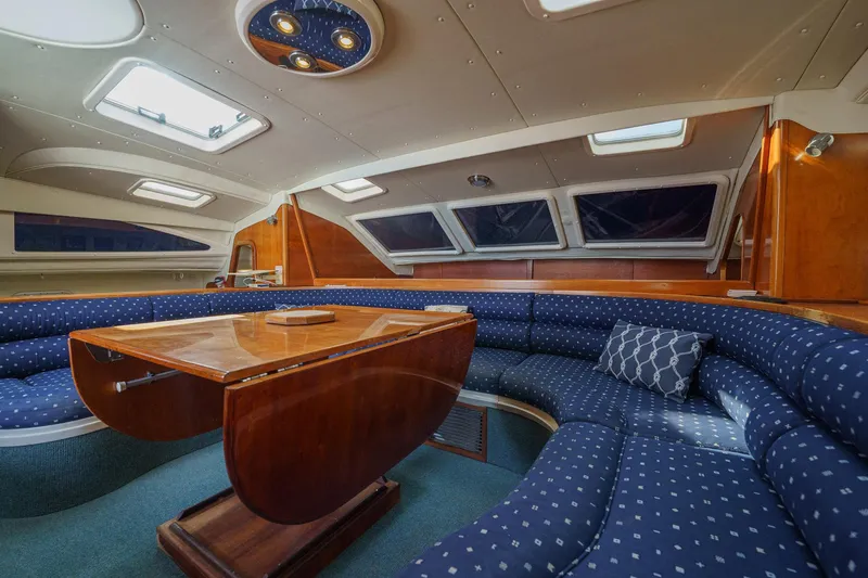 Solitude Yacht Photos Pics Luxurious interior of a 1995 Prout 45 yacht with elegant seating and wooden table.