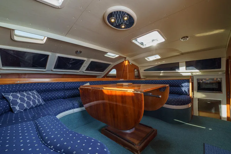 Solitude Yacht Photos Pics Luxurious interior of a 1995 Prout 45 yacht with elegant seating and wooden table.