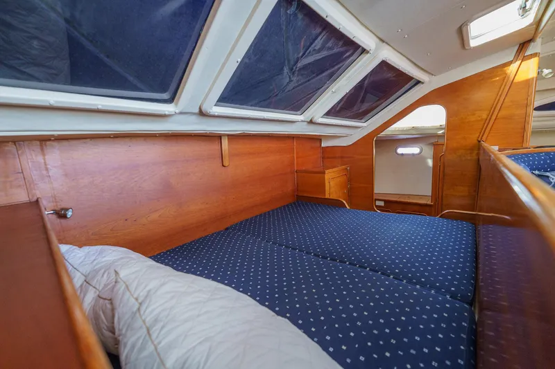 Solitude Yacht Photos Pics Cozy cabin interior of 1995 Prout 45 yacht with blue bedding and wooden finish.