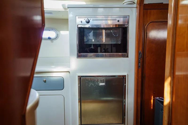 Solitude Yacht Photos Pics Interior of 1995 Prout 45 yacht featuring kitchen appliances and wooden cabinetry.