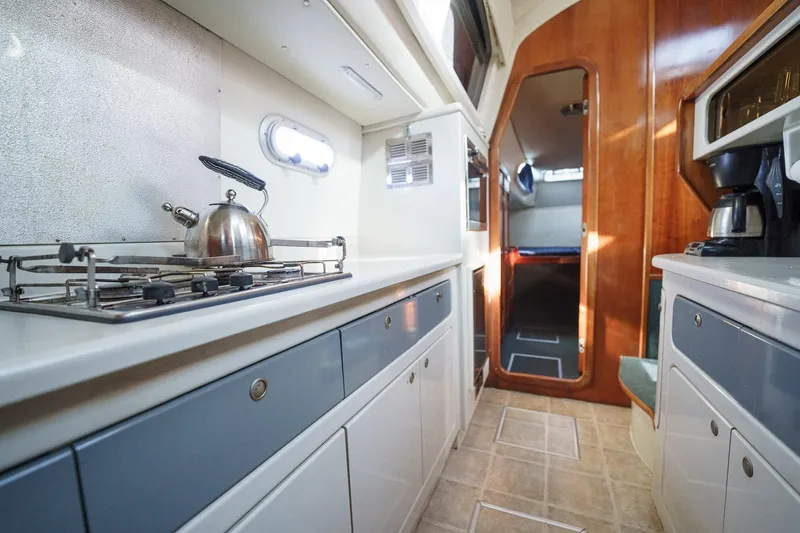 Solitude Yacht Photos Pics Prout 45 yacht kitchen interior, featuring stove, kettle, and wooden cabinetry, 1995 model.