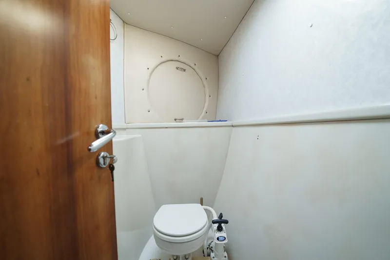 Solitude Yacht Photos Pics Boat bathroom interior with white walls and wooden door, Prout 45, 1995 model.