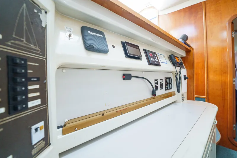 Solitude Yacht Photos Pics Navigation panel inside a 1995 Prout 45 yacht, featuring control systems and communication devices.